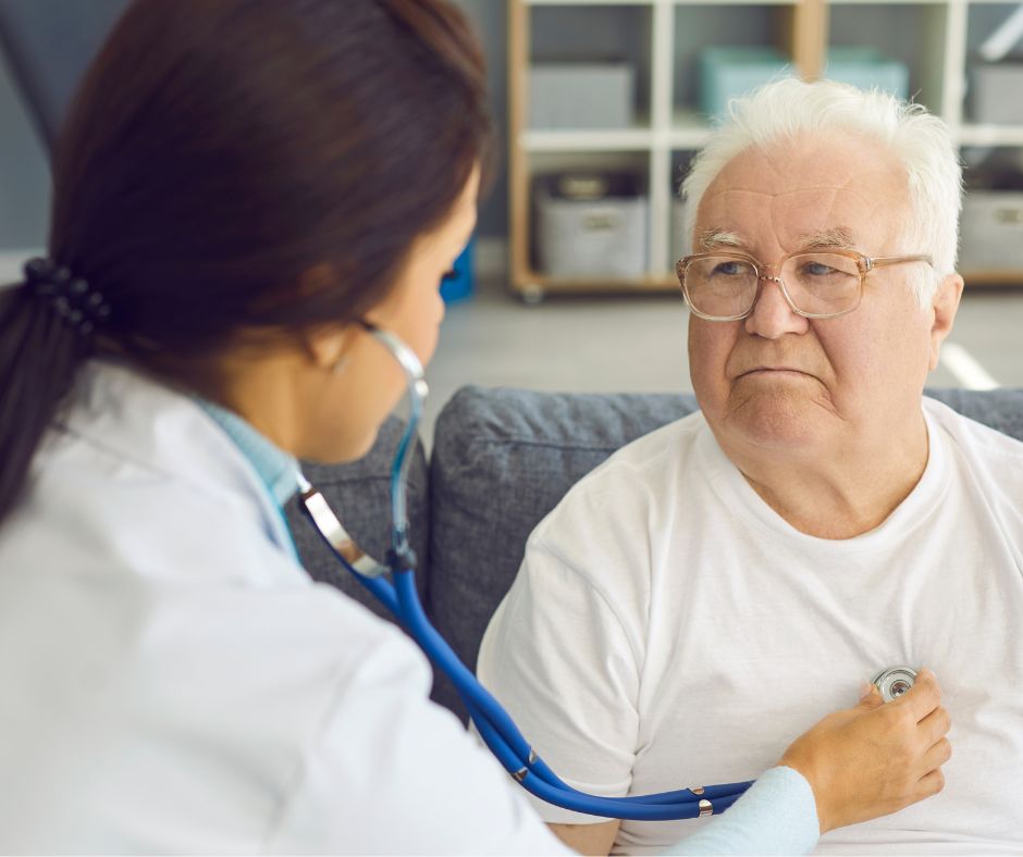 cardiologo domiciliare adi salus visita cuore Cardiologa di ADI Salus che utilizza uno stetoscopio per controllare il cuore di un paziente anziano durante una visita