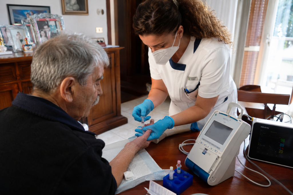 Infermiere esegue prelievo arterioso per emogasanalisi a domicilio in ambiente domestico